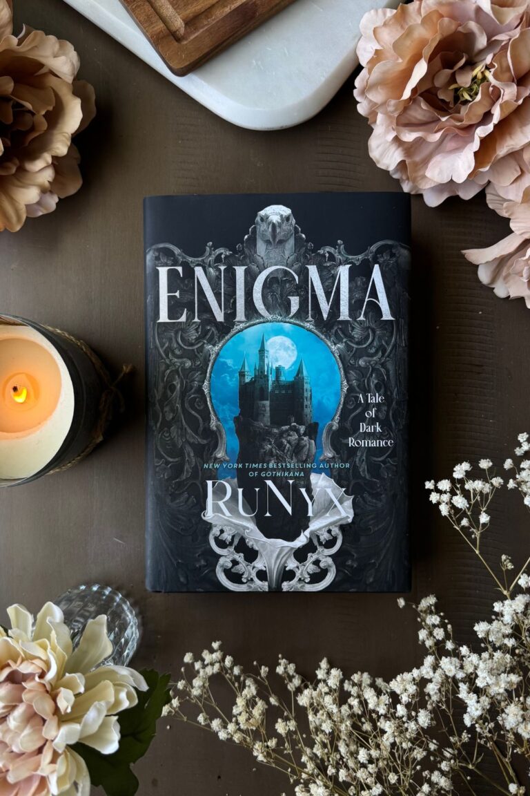 Enigma book flat lay with flowers and candle