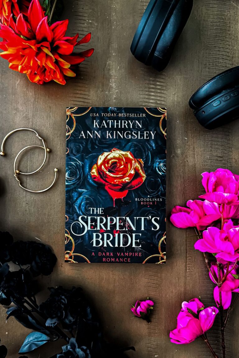 The Serpent's Bride book on a brown table with flowers.