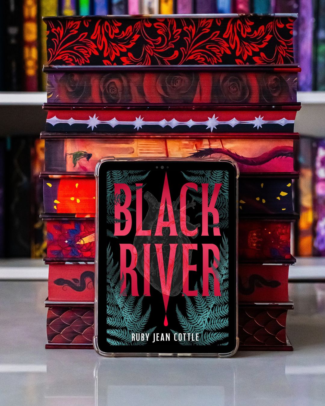 black river ebook with books stacked behind it.