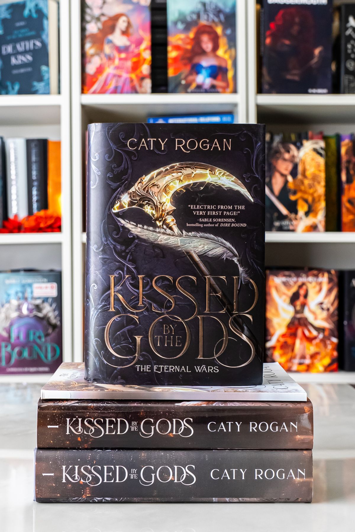 a stack of different versions of kissed by the gods.